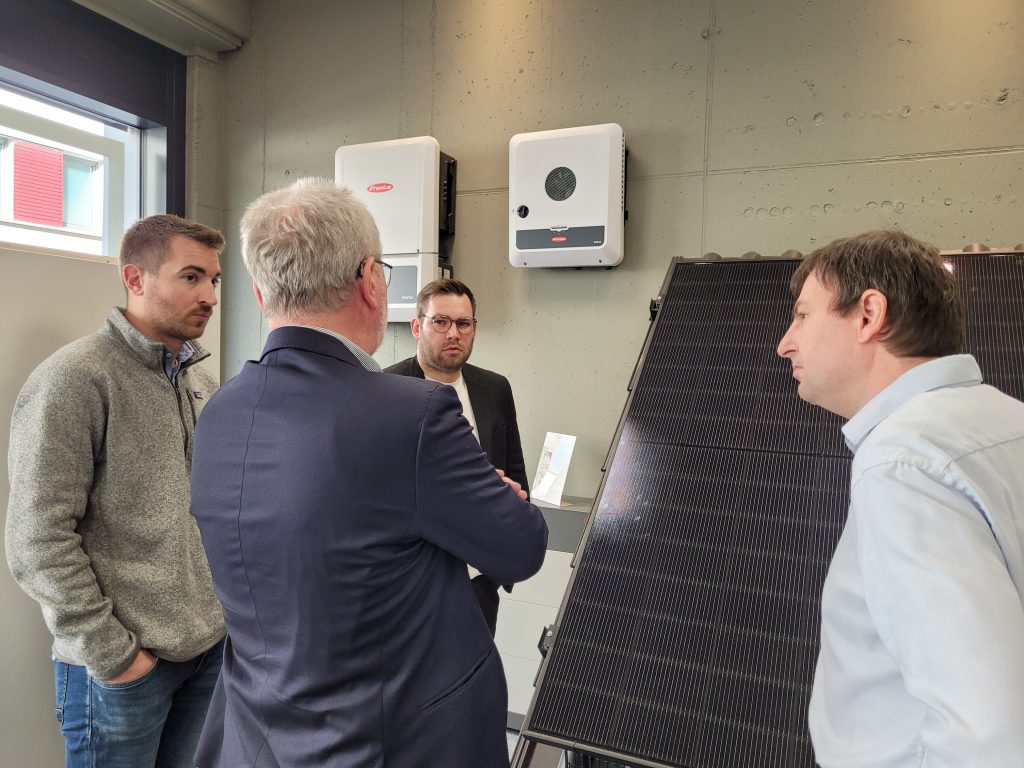 GEDEA-Ingelheim Geschäftsführung stehend im Gespräch mit Daniel Baldy MdB zu Solarmodulen im Showroom.